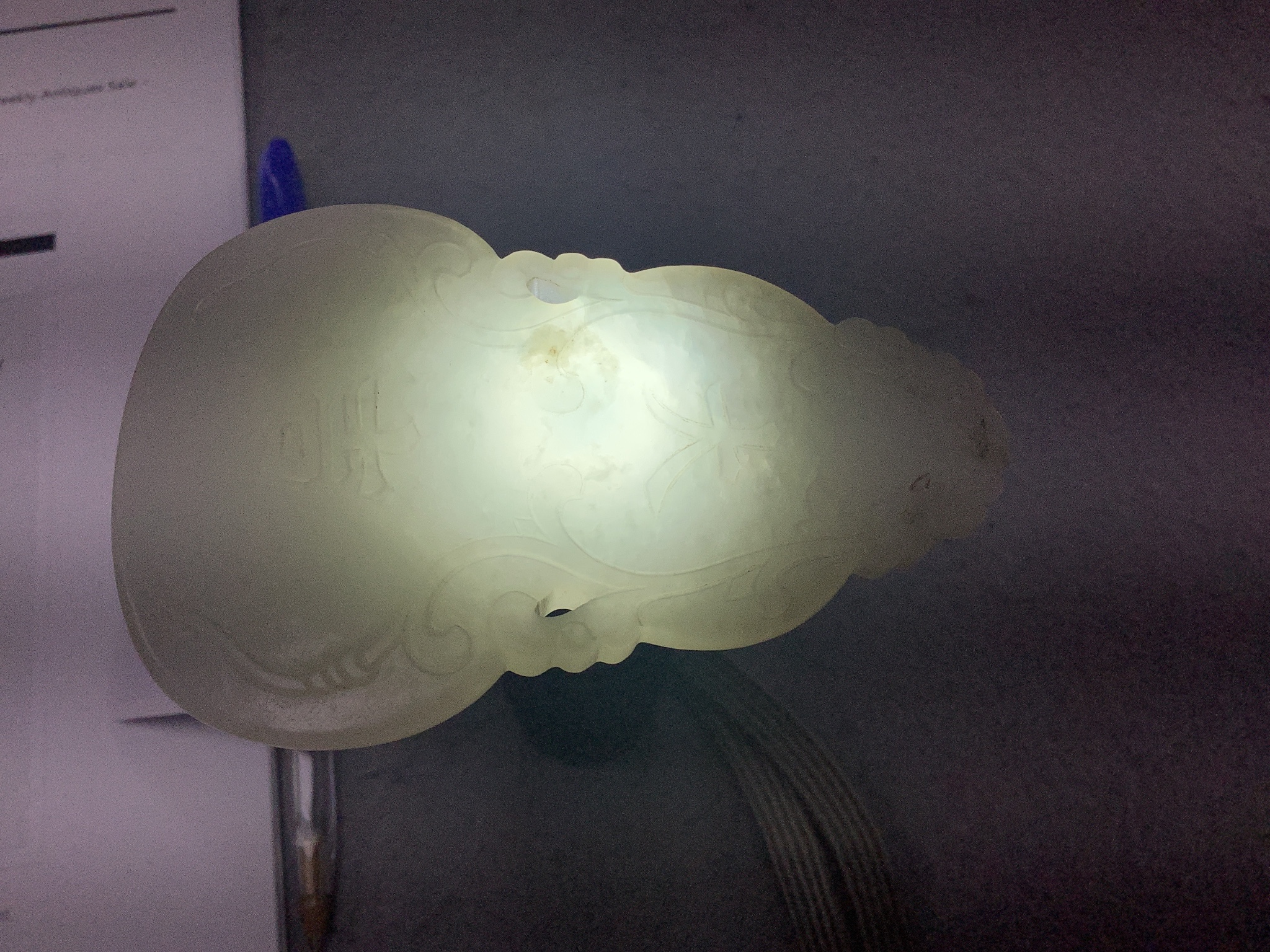 A Chinese inscribed white jade gourd shaped plaque on stand, with calligraphy, 12cms high.
